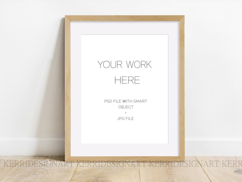 Puede incluir: Un marco de madera clara con un paspart&uacute; blanco y un fondo blanco. El texto "YOUR WORK HERE" est&aacute; impreso en el centro del marco. Debajo del texto se encuentra "PSD FILE WITH SMART OBJECT" y "JPG FILE".
