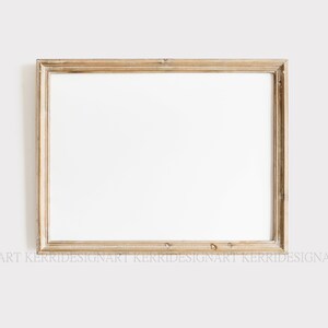 May include: A rectangular, gold-toned picture frame with a white interior. The frame has a distressed, vintage appearance, with visible wood grain and small, decorative pegs. The frame is set against a plain, off-white background.