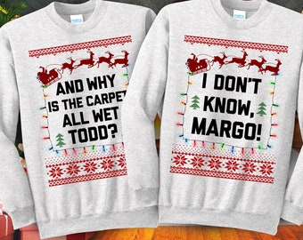 May include: A pair of grey Christmas jumpers with a red and white festive design. One jumper says "And why is the carpet all wet Todd?" and the other says "I don't know, Margo!"