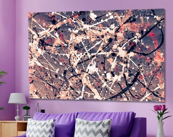 May include: Abstract art print with black, white, and brown paint splatters on a purple background. The print is hanging on a purple wall above a purple sofa with gray pillows.