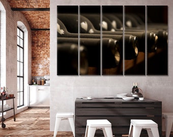 May include: A close-up of a row of wine bottles in a dark wooden wine rack. The bottles are all dark glass and have a vintage feel.