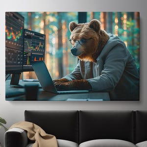 May include: A canvas print featuring a bear wearing glasses and a hoodie, working on a laptop. Two computer monitors display stock market charts. The background shows a blurred forest scene.