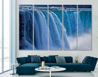 May include: A multi-panel canvas print featuring a close-up of a waterfall. The water is a vibrant blue and white, creating a sense of movement and energy. The print is perfect for adding a touch of nature to any room.