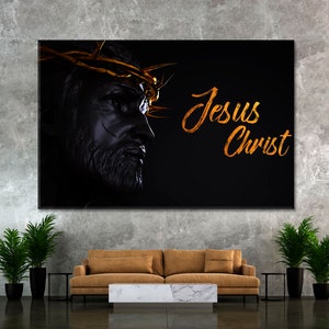 May include: A black and white image of Jesus Christ with a crown of thorns. The text "Jesus Christ" is written in gold script on a black background.