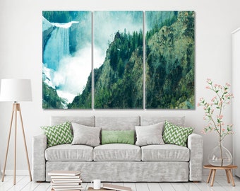 May include: A three-panel canvas art print depicting a waterfall cascading down a rocky cliff face. The artwork features shades of blue, green, and white, with a textured, painterly effect. The print is displayed above a gray sofa with green and gray pillows.