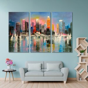 May include: A colorful abstract painting of a cityscape with sailboats in the foreground. The city is reflected in the water. The painting is divided into three panels.