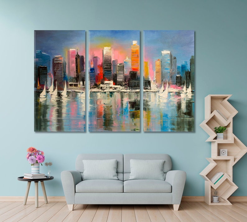 May include: A colorful abstract painting of a cityscape with sailboats in the foreground. The city is reflected in the water. The painting is divided into three panels.