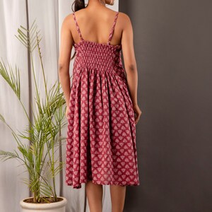 K&ouml;nnte beinhalten: Ein maronfarbenes Midikleid mit wei&szlig;em Blumenmuster. Das Kleid hat einen figurbetonten Oberteil und einen flie&szlig;enden Rock. Die Tr&auml;ger sind d&uuml;nn und verstellbar. Das Kleid ist aus einem weichen, bequemen Stoff gefertigt.