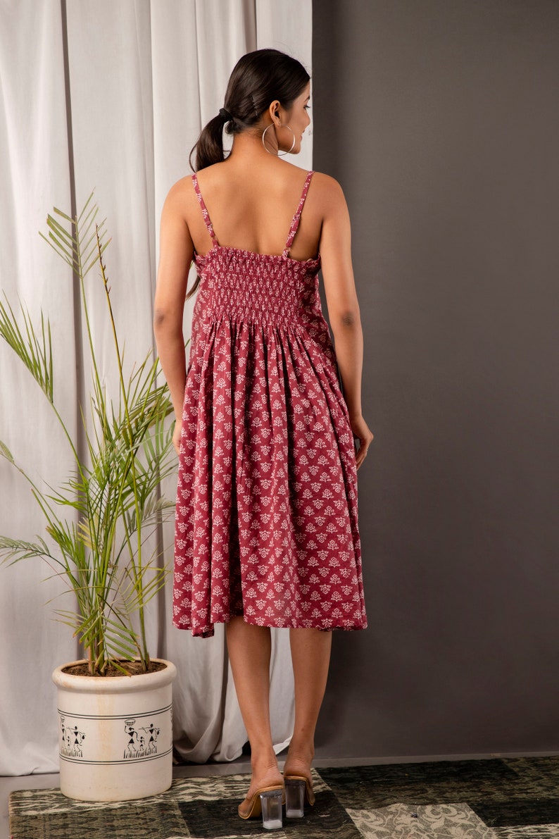 K&ouml;nnte beinhalten: Ein maronfarbenes Midikleid mit wei&szlig;em Blumenmuster. Das Kleid hat einen figurbetonten Oberteil und einen flie&szlig;enden Rock. Die Tr&auml;ger sind d&uuml;nn und verstellbar. Das Kleid ist aus einem weichen, bequemen Stoff gefertigt.
