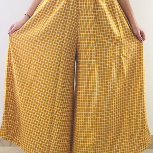 Puede incluir: Pantal&oacute;n de pierna ancha en color amarillo mostaza con estampado de cuadros blancos. El pantal&oacute;n tiene una cintura el&aacute;stica con cord&oacute;n.