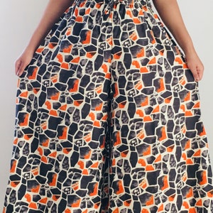 Puede incluir: Pantal&oacute;n de pierna ancha con un patr&oacute;n geom&eacute;trico negro y naranja. El pantal&oacute;n tiene una cintura el&aacute;stica con cord&oacute;n.