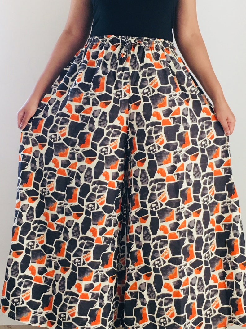 Puede incluir: Pantal&oacute;n de pierna ancha con un patr&oacute;n geom&eacute;trico negro y naranja. El pantal&oacute;n tiene una cintura el&aacute;stica con cord&oacute;n.