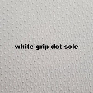 May include: White grip dot sole. The sole of a shoe or boot with a white, textured, dot pattern.