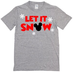 May include: A gray t-shirt with the text "Let It Snow" in red letters and a black Mickey Mouse head in the middle of the word "Snow".