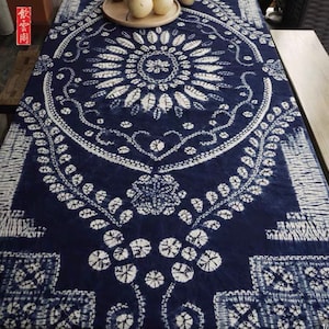 Peut inclure: Un chemin de table bleu et blanc avec un motif circulaire de feuilles et de fleurs. Le chemin de table a un design japonais traditionnel.