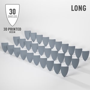 May include: A long row of 30 grey 3D printed resin shields. The shields are arranged in a staggered pattern, with each shield slightly overlapping the one below it. The shields are all the same size and shape, and they have a smooth, matt finish.