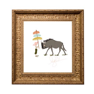 May include: A framed art print featuring a whimsical illustration. It depicts a gray wildebeest walking on grass, accompanied by a person holding colorful parasols. The artwork is signed and set within a gold ornate frame, suitable for wall decor.