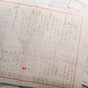 May include: A close-up of a handwritten document with a grid pattern and Japanese characters. The document is filled with mathematical equations and calculations.