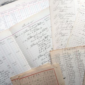 May include: A collection of vintage ledger pages with handwritten entries and numbers. The pages are yellowed with age and have a worn, textured surface. Some of the pages have ruled lines and columns, while others are blank. The pages are stacked on top of each other, creating a layered effect.