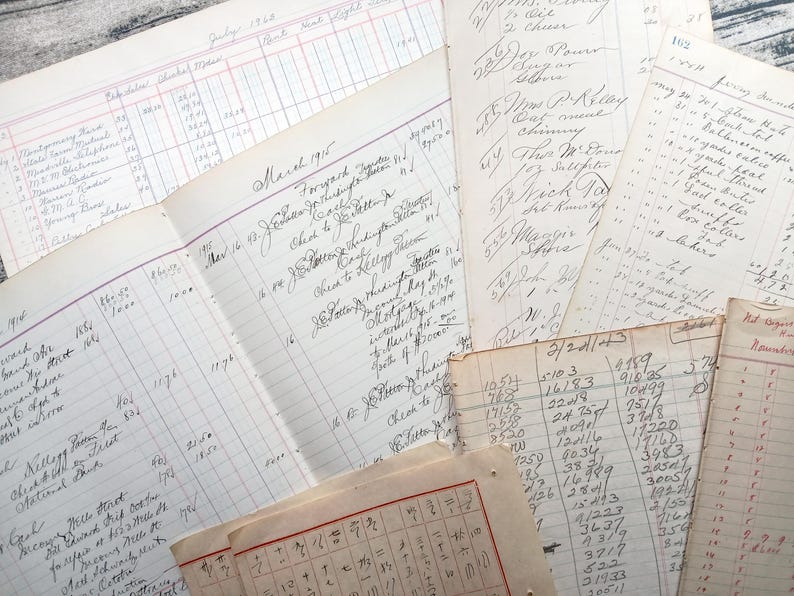 May include: A collection of vintage ledger pages with handwritten entries and numbers. The pages are yellowed with age and have a worn, textured surface. Some of the pages have ruled lines and columns, while others are blank. The pages are stacked on top of each other, creating a layered effect.