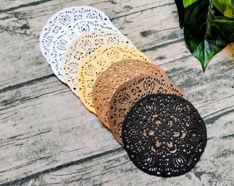 May include: A set of seven round, decorative paper doilies in various shades of brown, gold, and white. The doilies have a delicate, intricate lace pattern.