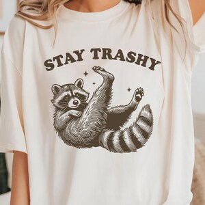 Bleiben Sie trashig T-Shirt, lustiges Retro Waschbär Shirt, Cottagecore T-Shirt, Waschbär Meme Shirt, Waschbär-Liebhaber Geschenk, Tier lustiges Shirt