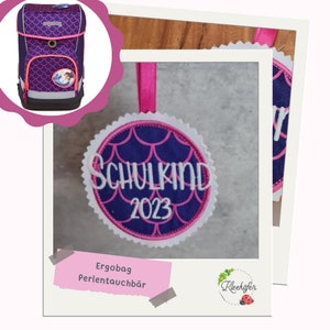 Könnte beinhalten: Eine weiße Keramik-Tasse mit schwarzem Henkel und dem Text "But First, Coffee" in fetter, schwarzer Schrift. Die Tasse steht vor einem verschwommenen Hintergrund, der eine gemütliche Umgebung andeutet.