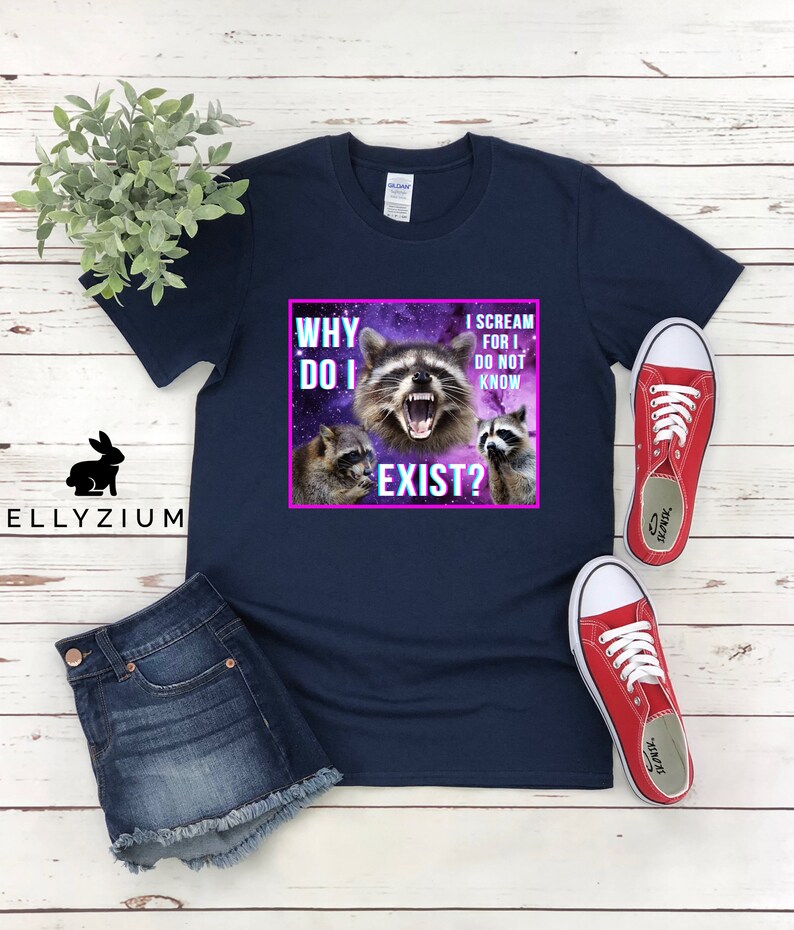 May include: A navy blue t-shirt with a graphic of three raccoons in a galaxy background. The text on the shirt reads "Why do I exist? I scream for I do not know."