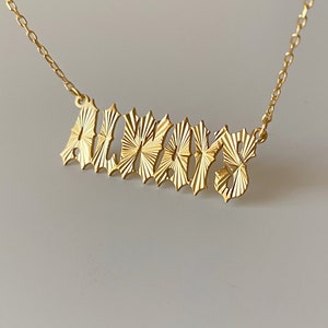 Puede incluir: Collar de oro con un colgante texturizado 'ALWAYS'.
