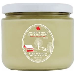 May include: A glass jar of maple cream with a white lid. The label is white with red and black text that reads "Covered Bridge Maple Sugaring Milking Trees Since 1989 CRMSD Pure Vermont Maple Cream Net Wt 1 lb (453.6g)".