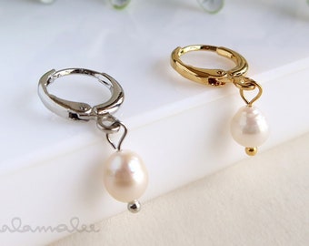 May include: Two pairs of earrings with pearl drops. One pair has a silver hoop and the other has a gold hoop.
