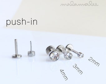May include: Three sizes of clear crystal push-in stud earrings in silver settings. The earrings are 2mm, 3mm, and 4mm in diameter.