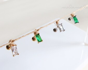 May include: A close-up of four different earrings with a gold or silver post and a green or clear rectangular stone.