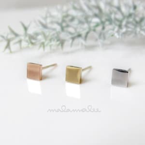 May include: Three square stud earrings in gold, rose gold, and silver.