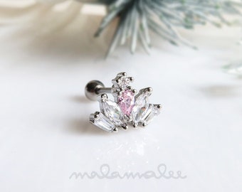 May include: A silver body jewelry piece with a pink and clear crystal crown design.