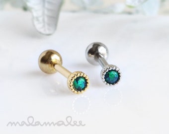May include: Two gold and silver barbell earrings with green opal gemstones. The earrings have a small ball on one end and a small gemstone on the other end.