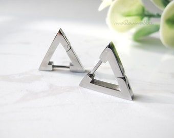 Peut inclure: Une paire de boucles d'oreilles créoles en forme de triangle argentées. Les boucles d'oreilles sont à charnière et ont un design simple et moderne.