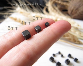 May include: Three black square stud earrings in different sizes: 3mm, 4mm, and 5mm. The earrings are shown on a finger.