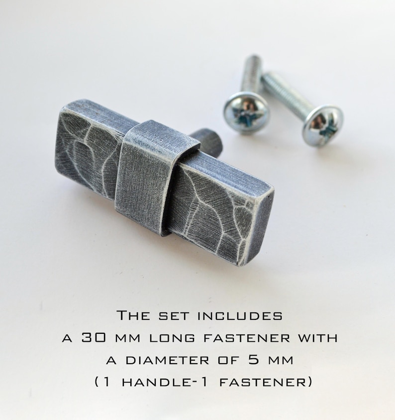 May include: A set of gray metal cabinet hardware. The set includes a 30 mm long fastener with a 5 mm diameter. The handle has a textured surface and is accompanied by two screws.