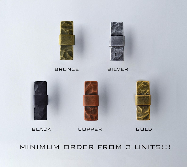 May include: An assortment of five metal cabinet pulls in bronze, silver, black, copper, and gold. Each pull has a textured rectangular body with a connecting band. The text "BRONZE", "SILVER", "BLACK", "COPPER", and "GOLD" are below each pull. The text "MINIMUM ORDER FROM 3 UNITS!!!" is at the bottom.