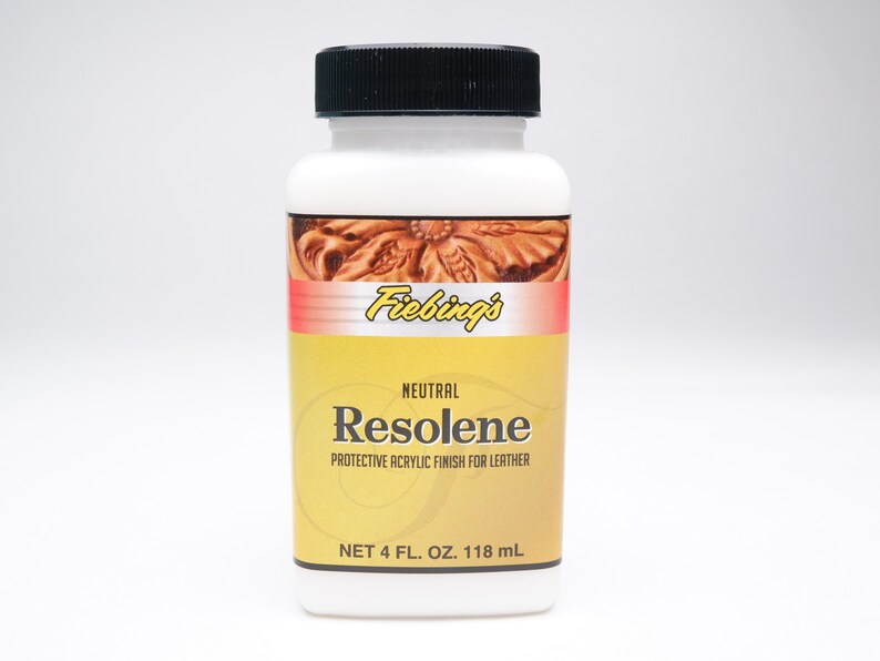 以下が含まれることがあります： Fiebing's Resoleneの白いプラスチックボトル。革用の保護アクリル仕上げです。ラベルは黄色で赤いアクセントがあり、製品名とブランドが表示されています。ボトルには118 mlの製品が入っており、黒いキャップが付いています。