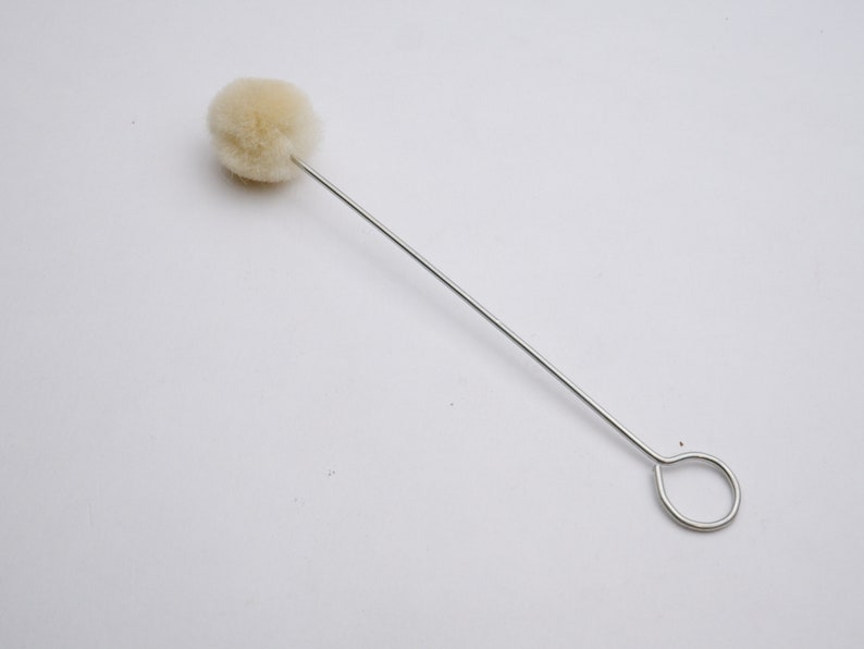 May include: A white cotton swab on a thin metal wire with a loop at the end.