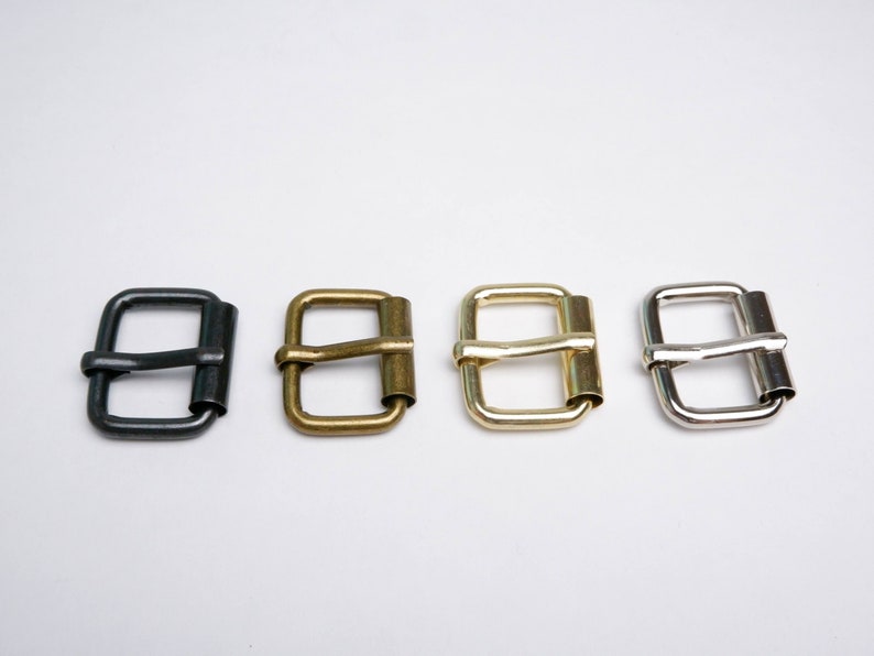 May include: Four metal belt buckles in different finishes: black, brass, gold, and silver.