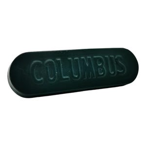 以下が含まれることがあります： 白い文字で「COLUMBUS」とエンボス加工された、濃い緑色の楕円形の看板です。
