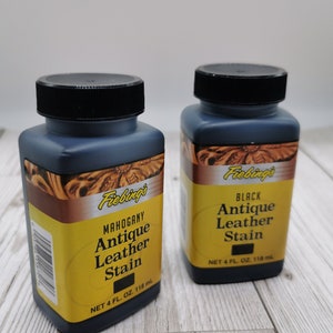 Op de afbeelding: Twee flessen Fiebing's Antique Leather Stain, &eacute;&eacute;n in mahonie en &eacute;&eacute;n in zwart. Elke fles bevat 118 ml (4 fl oz).