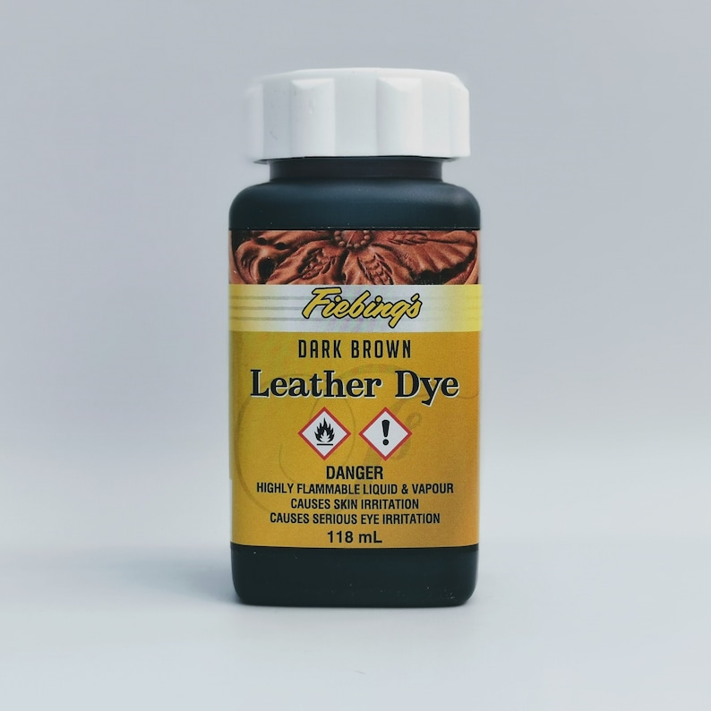 May include: A bottle of Fiebing's Dark Brown Leather Dye. The bottle is black with a white lid and a yellow label with a warning symbol. The label reads "DANGER: HIGHLY FLAMMABLE LIQUID & VAPOUR CAUSES SKIN IRRITATION CAUSES SERIOUS EYE IRRITATION 118 mL."