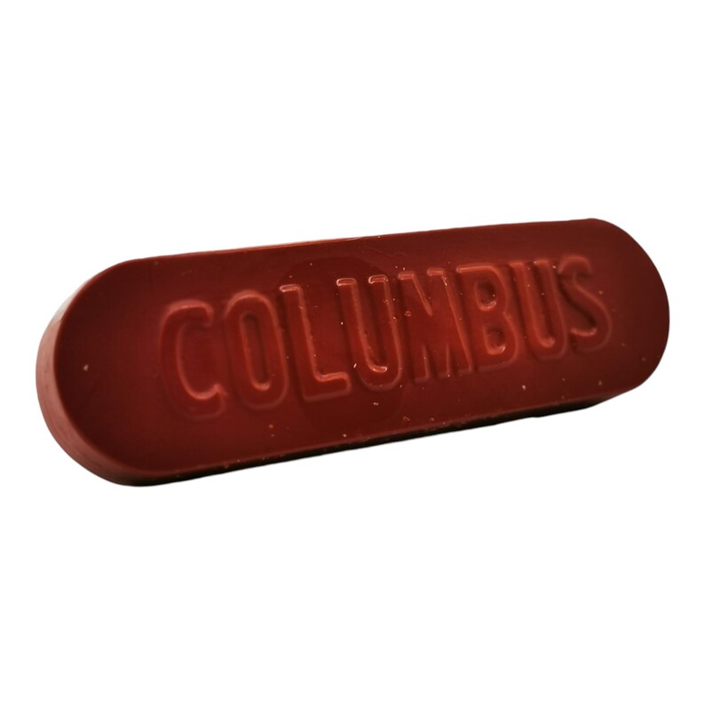 以下が含まれることがあります： 上面が「COLUMBUS」とエンボス加工された、赤色の長方形の靴磨きブロックです。
