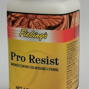 May include: A white plastic bottle with a black cap, labeled "Fiebing's Pro Resist." The label is yellow and red, with text indicating it maximizes contrast for antiquing and staining. Contains 4 fl oz (118 mL).