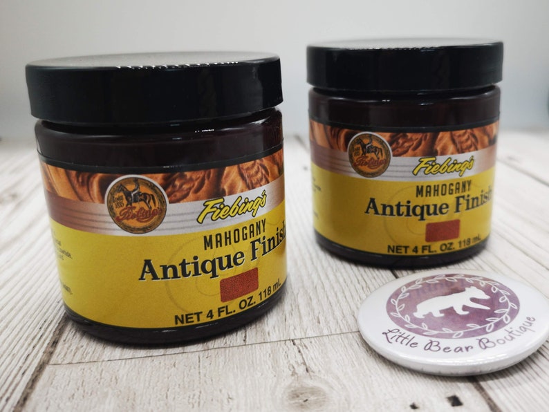 May include: Two 118 ml bottles of Fiebing's Mahogany Antique Finish leather dye. The bottles are brown with yellow labels and feature a horse and rider logo. The text on the label reads "Fiebing's Mahogany Antique Finish" and "Net 4 fl. oz. 118 ml".