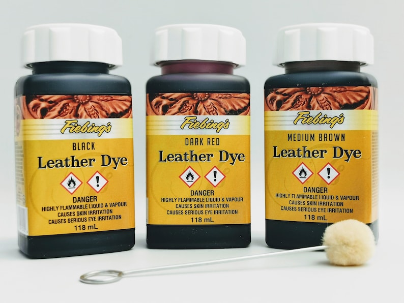 May include: Three bottles of Fiebing's Leather Dye in black, dark red, and medium brown. Each bottle is labeled with the color and contains 118 ml of dye. A small applicator brush is included.